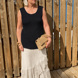 Woman wearing the Elvi loose singlet #101 in black with a cream skirt