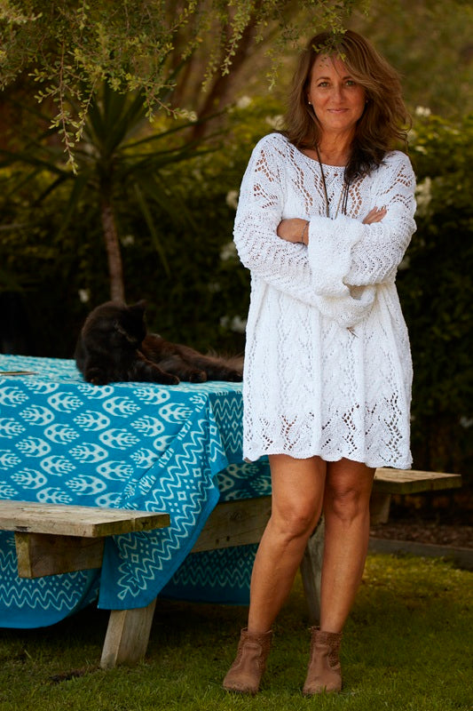 Woman wearing the Lace Tunic #107 in white, knitted in five lace patterns