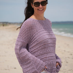 Woman by the sea in the lilac Bell Sleeve Sweater #115, showing the wide bell sleeves
