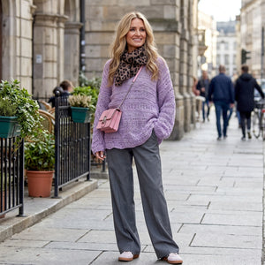 Woman walking a city street in the lilac Bell Sleeve Sweater #115 with grey wide-leg trousers