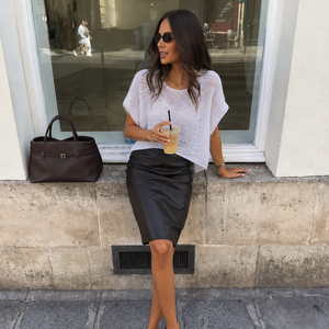 Tuva textured T-shirt #126 in white cotton, worn with a black skirt on a city window ledge