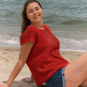 Woman on the beach wearing the Embla knitted t-shirt #132 in red