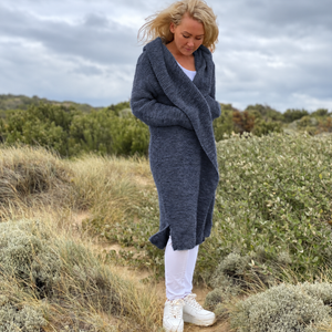 Elna hooded cardigan #133 in denim blue, knitted in chunky Scandi Soft XL and worn wrapped over white jeans