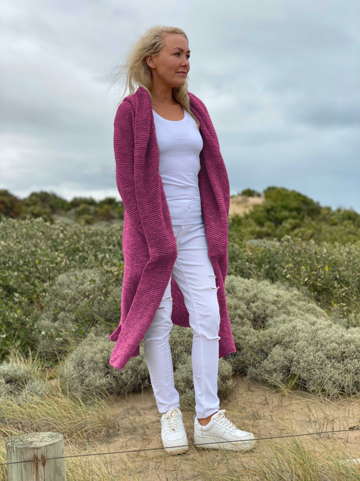 Elna hooded cardigan #133 in wild berry, worn open over white – a long knitted coat that reaches the knees