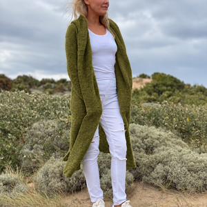 Elna hooded cardigan #133 in olive, worn open over a white top to show the long garter stitch fronts