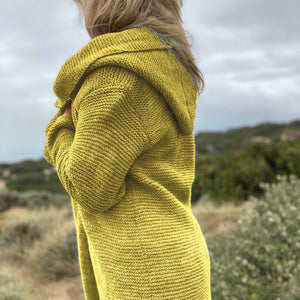 Side view of the Elna hooded cardigan #133 in chartreuse, showing the hood and the garter stitch texture of Scandi Soft XL