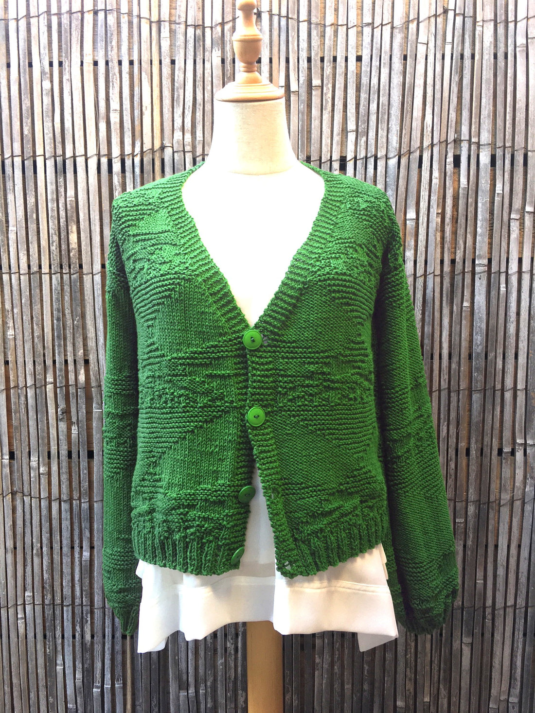 The Textured Cardigan #142 in emerald green with buttons, shown on a mannequin