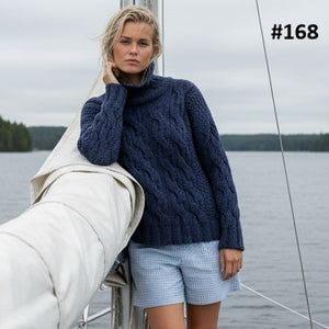 Woman by a boat wearing the Pia Cable Lace Roll Neck #168 knitted in Scandi Wool Denim