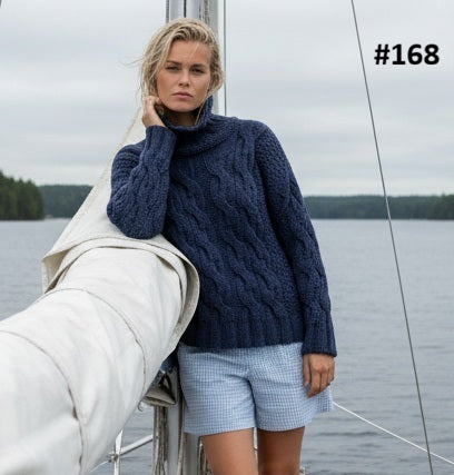 Woman by a boat wearing the Pia Cable Lace Roll Neck #168 knitted in Scandi Wool Denim
