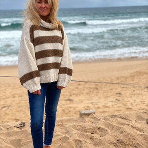 Svala Striped Sweater #182 with hazelnut stripes on ecru, worn with jeans on the beach