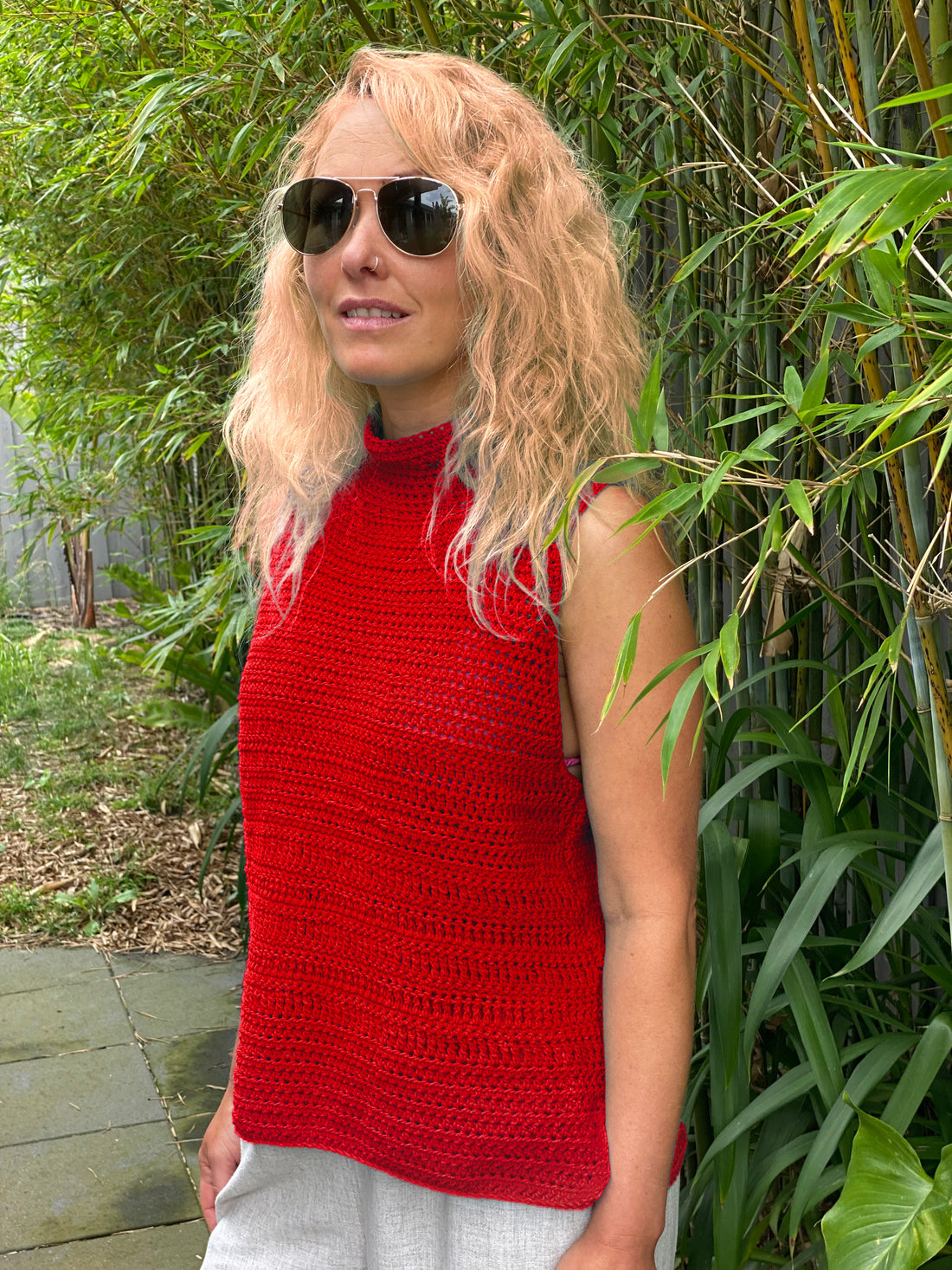 Woman in a garden wearing the Crochet Top #190 in red