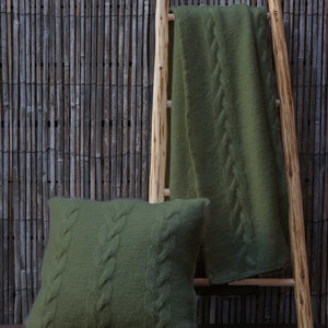 The Cable Cushion and Throw set #205 knitted in Scandi Wool Eucalyptus, shown on a wooden ladder