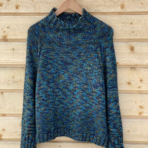 Nova Basic Sweater #304 in turquoise on a hanger, a seamless top-down raglan with a high collar