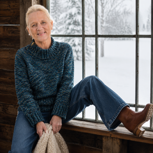 Nova Basic Sweater #304 in turquoise Snö, worn with wide jeans by a snowy window