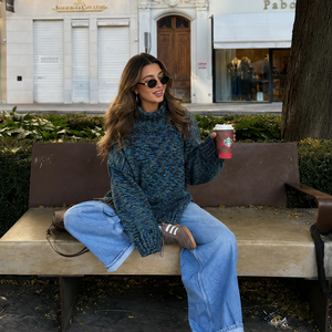 Nova Basic Sweater #304 in turquoise, worn with wide jeans on a bench in town