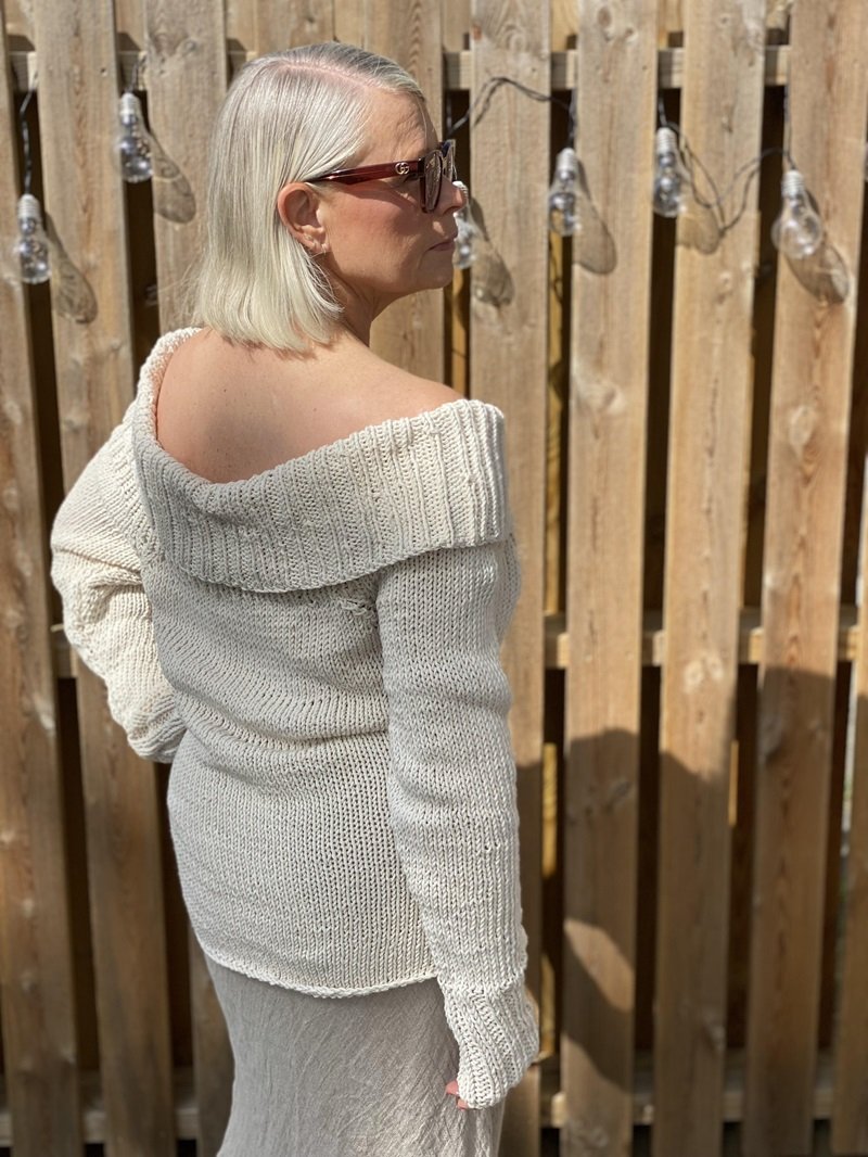 Woman wearing the Bardot off-shoulder jumper #125 in cream, worn off one shoulder