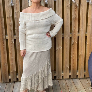 Woman wearing the Bardot off-shoulder jumper #125 in cream with a long cream skirt