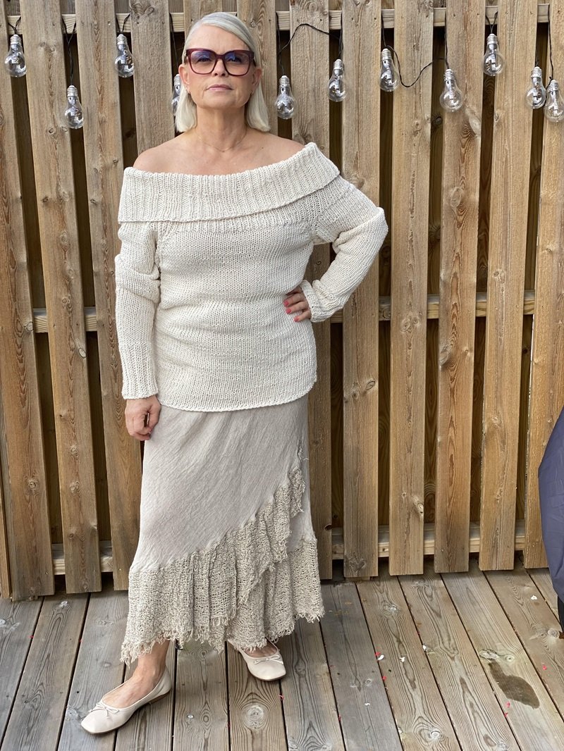 Woman wearing the Bardot off-shoulder jumper #125 in cream with a long cream skirt