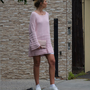 Woman wearing the Jumper Dress #136 in blossom pink on a street