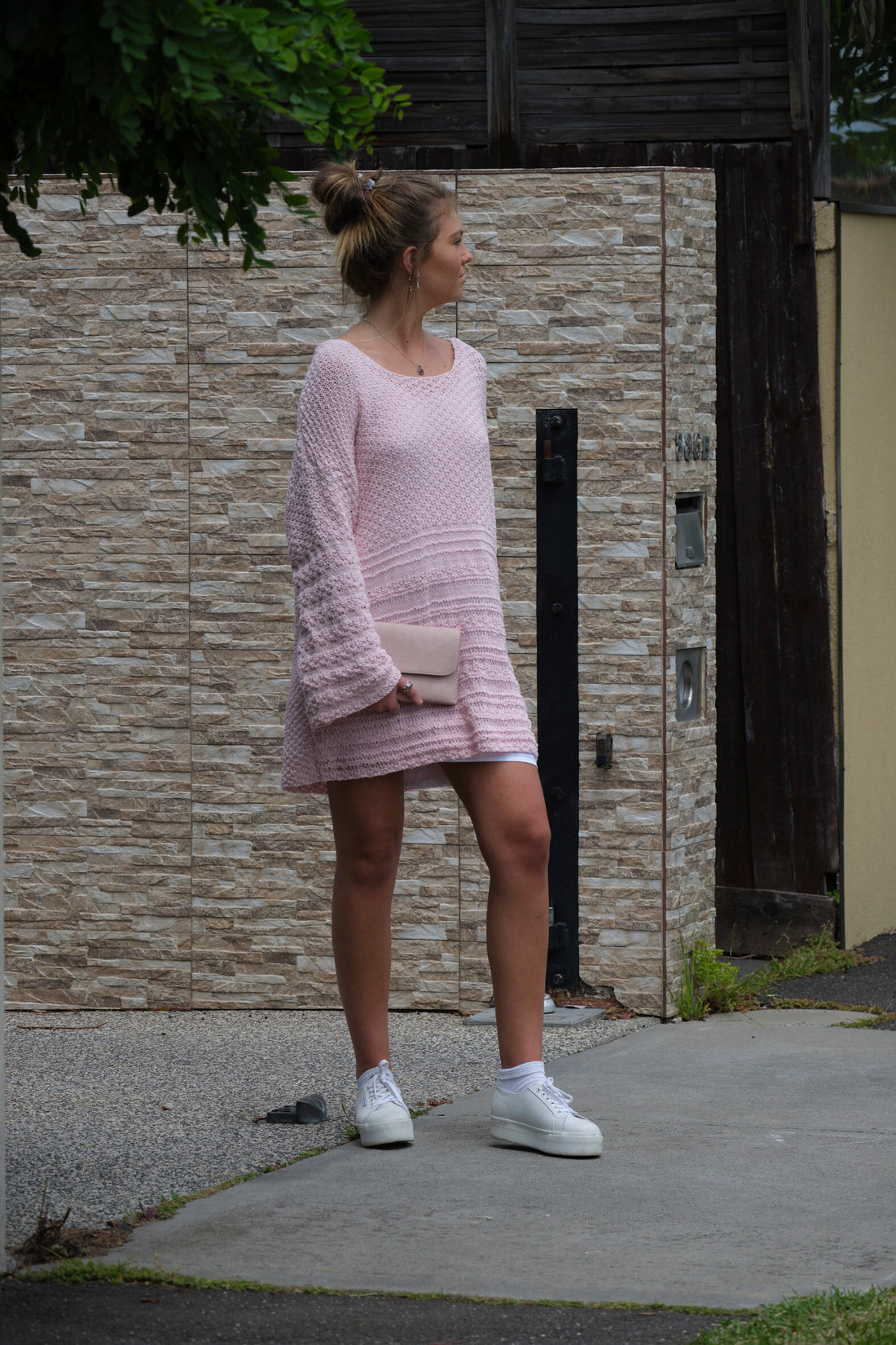 Woman wearing the Jumper Dress #136 in blossom pink on a street