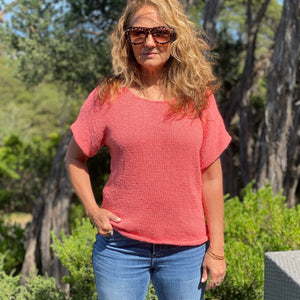 Woman wearing the Summer Top #174 in coral pink with jeans