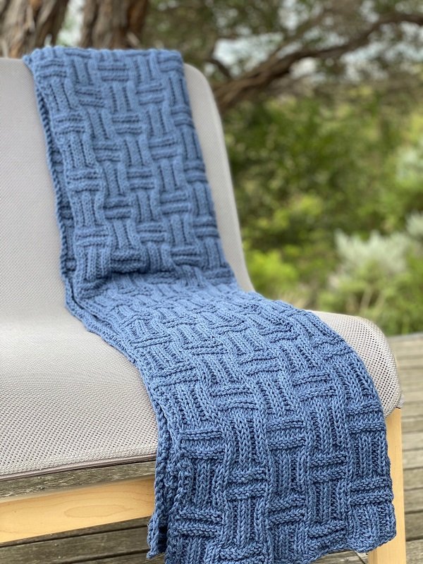 The Basket Throw #222 in indigo draped over a chair