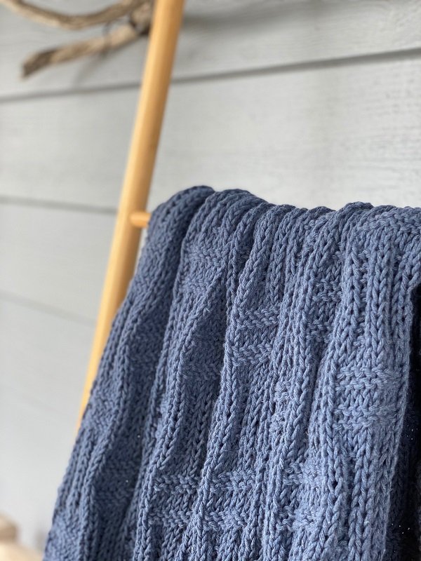 The Basket Throw #222 in indigo folded over a rail