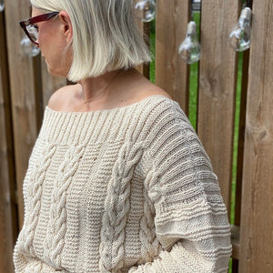 Woman wearing the Elisabeth cable jumper #113 in ecru, side view showing the textured sleeve