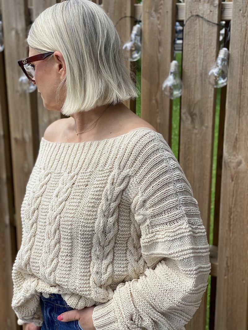 Woman wearing the Elisabeth cable jumper #113 in ecru, side view showing the textured sleeve